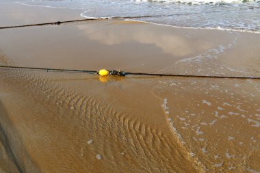 En banyo plaj yüzen bir ip ile çit yer 