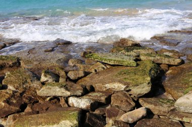 Akdeniz kıyısında açık bir parkta taş yalan 