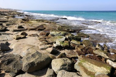 Akdeniz kıyısında açık bir parkta taş yalan 