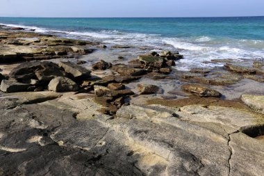 Akdeniz kıyısında açık bir parkta taş yalan 