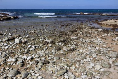 Akdeniz kıyısında açık bir parkta taş yalan 