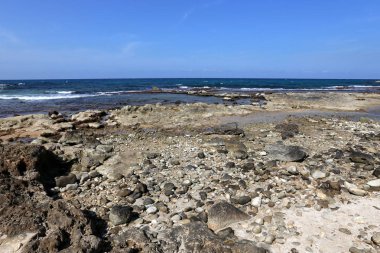 Akdeniz kıyısında açık bir parkta taş yalan 