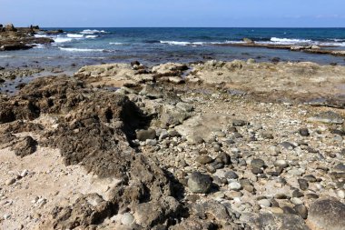 Akdeniz kıyısında açık bir parkta taş yalan 
