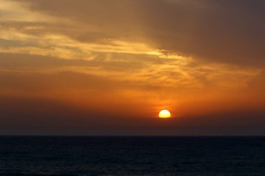 Güneş Kuzey İsrail'de Akdeniz'in ufkunda batıyor ve gün sona eriyor.