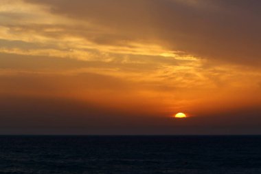 Güneş Kuzey İsrail'de Akdeniz'in ufkunda batıyor ve gün sona eriyor.