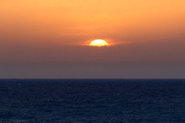 Güneş Kuzey İsrail'de Akdeniz'in ufkunda batıyor ve gün sona eriyor.