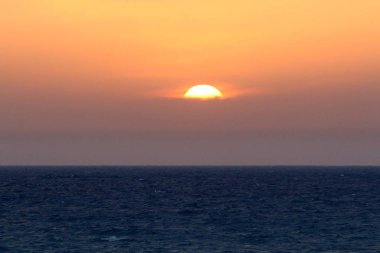 Güneş Kuzey İsrail'de Akdeniz'in ufkunda batıyor ve gün sona eriyor.