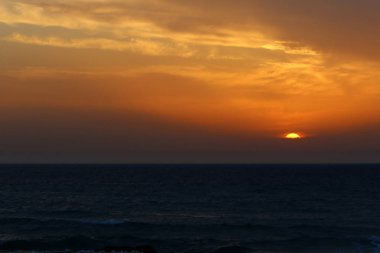 Güneş Kuzey İsrail'de Akdeniz'in ufkunda batıyor ve gün sona eriyor.