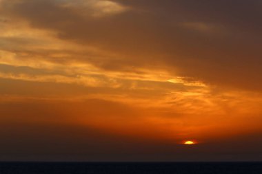 Güneş Kuzey İsrail'de Akdeniz'in ufkunda batıyor ve gün sona eriyor.