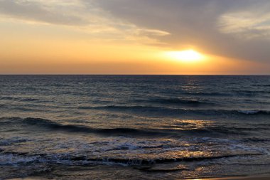Güneş Kuzey İsrail'de Akdeniz'in ufkunda batıyor ve gün sona eriyor.
