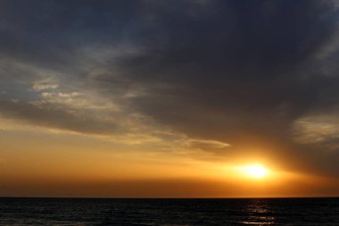 Güneş Kuzey İsrail'de Akdeniz'in ufkunda batıyor ve gün sona eriyor.