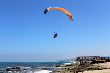 kuzey İsrail'de Akdeniz üzerinde adam yamaç paraşütleri 