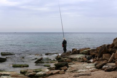 kuzey İsrail'de Akdeniz kıyılarında dinlenen adam 