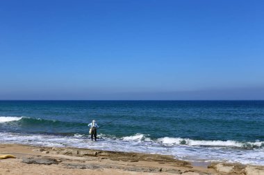 kuzey İsrail'de Akdeniz kıyılarında dinlenen adam 