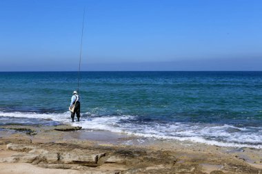 kuzey İsrail'de Akdeniz kıyılarında dinlenen adam 