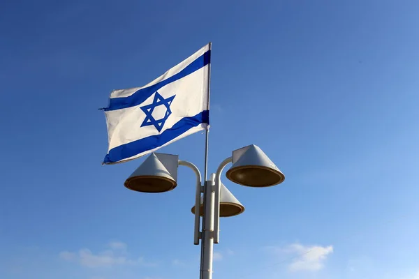 blue and white with the star of david the flag of Israel develops in the wind