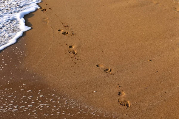 footprints in the sand on the shores of the Mediterranean in the north of the state of Israel