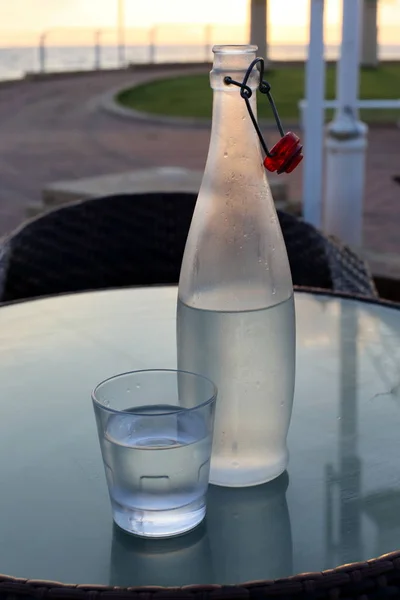 in a cafe on the table is a glass of cold, mineral water