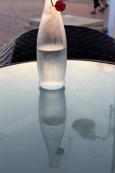 in a cafe on the table is a glass of cold, mineral water