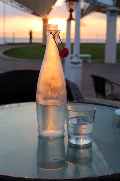 in a cafe on the table is a glass of cold, mineral water