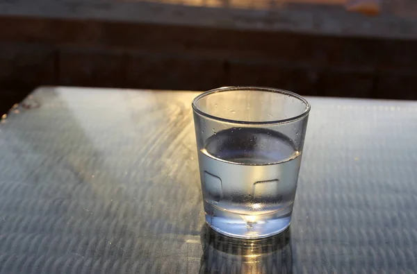 in a cafe on the table is a glass of cold, mineral water