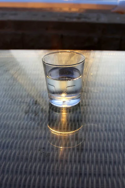 in a cafe on the table is a glass of cold, mineral water