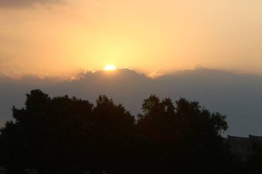 İsrail'de Akdeniz kıyılarında bulutlu gökyüzünde sabah erken ve gündoğumu 