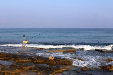 adam dinlenir ve kuzey İsrail'de Akdeniz kıyılarında spor oynar 