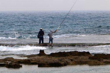 adam dinlenir ve kuzey İsrail'de Akdeniz kıyılarında spor oynar 