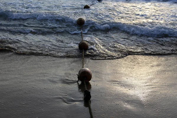 在以色列国北部地中海海岸的海滩上用浮子栅栏的绳子 — 图库照片