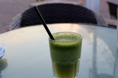 deniz kıyısında bir restoranda masada soğuk su ve alkolsüz içecek ile bir bardak var 