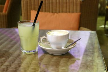 deniz kıyısında bir restoranda masada soğuk su ve alkolsüz içecek ile bir bardak var 