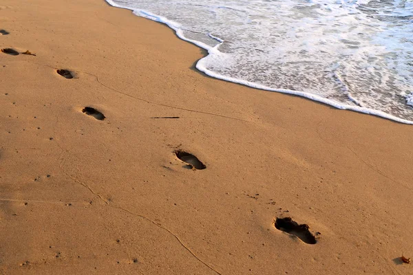 footprints in the sand on the beach on the Mediterranean coast in the north of the state of Israel