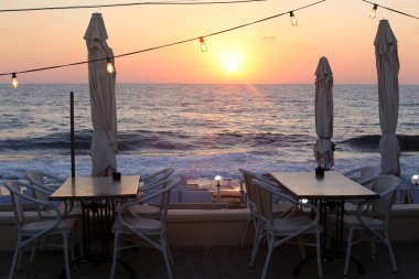 Israil 'de Akdeniz 'in kıyılarında bir kafede sandalye ve masa ayakta 