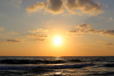 Kuzey İsrail'de Akdeniz'de ufukta güneş batıyor ve gece çöküyor. 