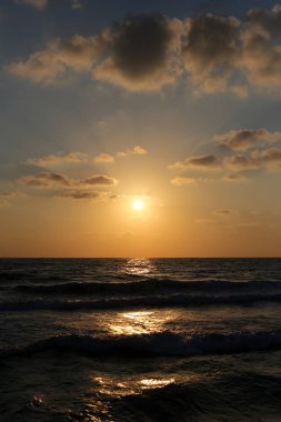 Kuzey İsrail'de Akdeniz'de ufukta güneş batıyor ve gece çöküyor. 
