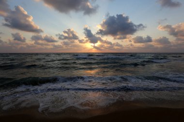 Kuzey İsrail'de Akdeniz'de ufukta güneş batıyor ve gece çöküyor. 