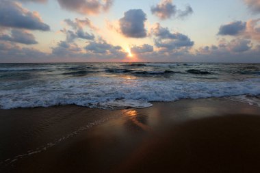 Kuzey İsrail'de Akdeniz'de ufukta güneş batıyor ve gece çöküyor. 