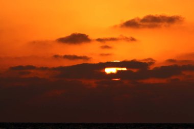 Kuzey İsrail'de Akdeniz'de ufukta güneş batıyor ve gece çöküyor. 