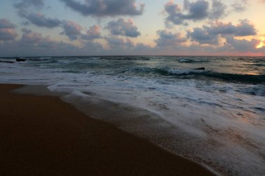 Kuzey İsrail'de Akdeniz'de ufukta güneş batıyor ve gece çöküyor. 