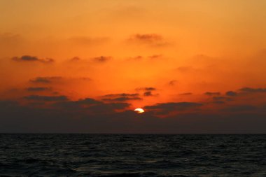 Kuzey İsrail'de Akdeniz'de ufukta güneş batıyor ve gece çöküyor. 