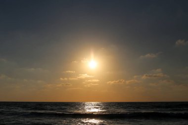 Kuzey İsrail'de Akdeniz'de ufukta güneş batıyor ve gece çöküyor. 