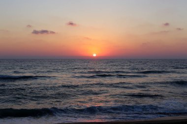 Kuzey İsrail'de Akdeniz'de ufukta güneş batıyor ve gece çöküyor. 