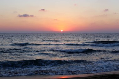 Kuzey İsrail'de Akdeniz'de ufukta güneş batıyor ve gece çöküyor. 