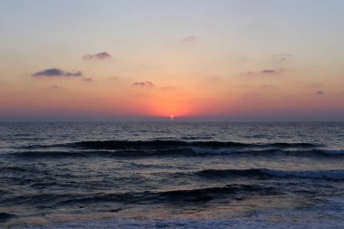 Kuzey İsrail'de Akdeniz'de ufukta güneş batıyor ve gece çöküyor. 