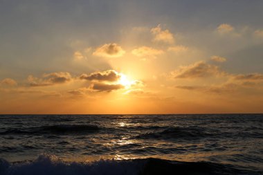 Kuzey İsrail'de Akdeniz'de ufukta güneş batıyor ve gece çöküyor. 