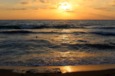 Kuzey İsrail'de Akdeniz'de ufukta güneş batıyor ve gece çöküyor. 
