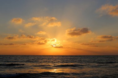 Kuzey İsrail'de Akdeniz'de ufukta güneş batıyor ve gece çöküyor. 