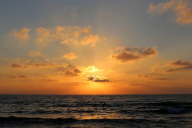 Kuzey İsrail'de Akdeniz'de ufukta güneş batıyor ve gece çöküyor. 