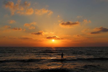 Kuzey İsrail'de Akdeniz'de ufukta güneş batıyor ve gece çöküyor. 